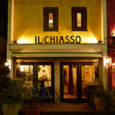 イエローの外壁に大きな「IL CHIASSO」の店名が目印