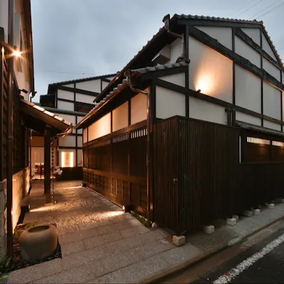 石畳のアプローチと窓格子からもれる灯り、ほっと一息つける町屋風建築