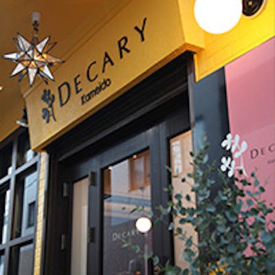 山吹色と茶の鮮やかな外観、遊び心ある内装と存在感ある“DECARY”がお出迎え