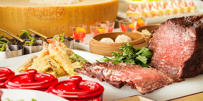 ジューシーなお肉や天ぷらがテーブルに盛られている