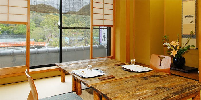 窓から宇治川の風景が見える京料理店「辰巳屋」の店内