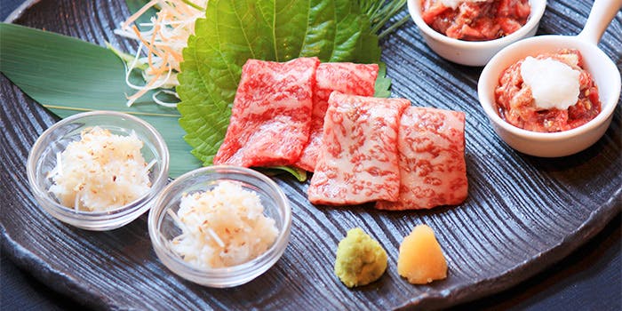 青山まんぷくの肉料理がテーブルの上に置かれている様子