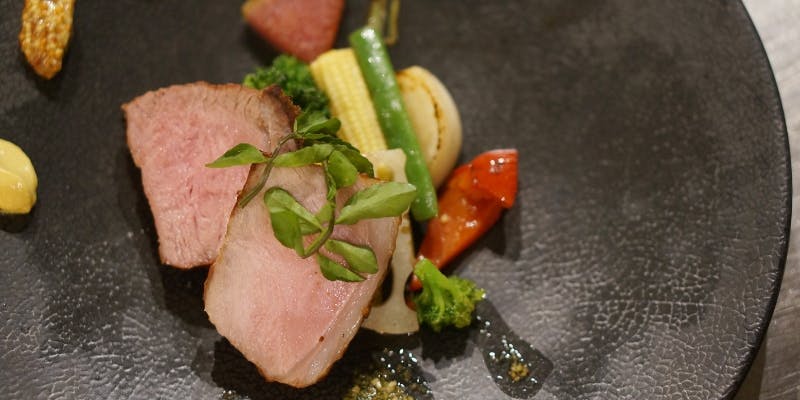 アン カフェの肉料理がテーブルの上に置かれている様子