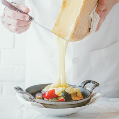 カシーナ名物料理ラクレット とろとろに溶かしたチーズをお野菜やお肉にかけます