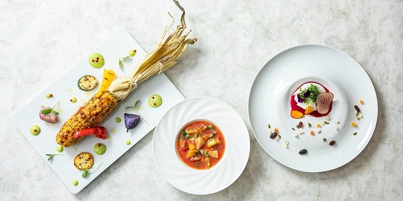 とうもろこしのグリルやトマトスープ、デザートがテーブルの上に置いてある