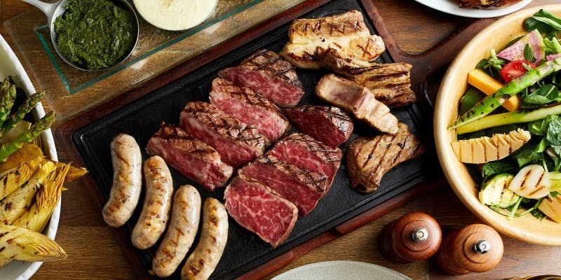 黒いプレートにのったステーキやソーセージ