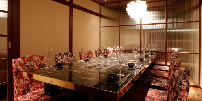 黒いテーブルと花柄の椅子が並ぶ和風な銀座 肉料理 小次郎の店内