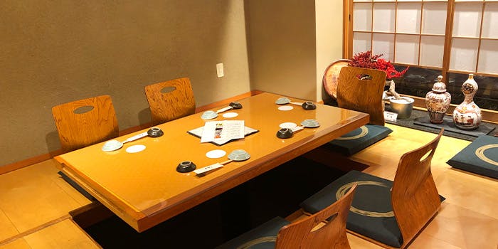 木目調のテーブルと椅子が置かれた座敷席