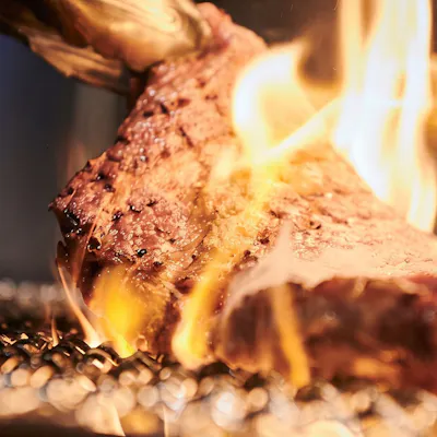 オープンキッチンで焼き上げる豪快な炭火焼き肉料理