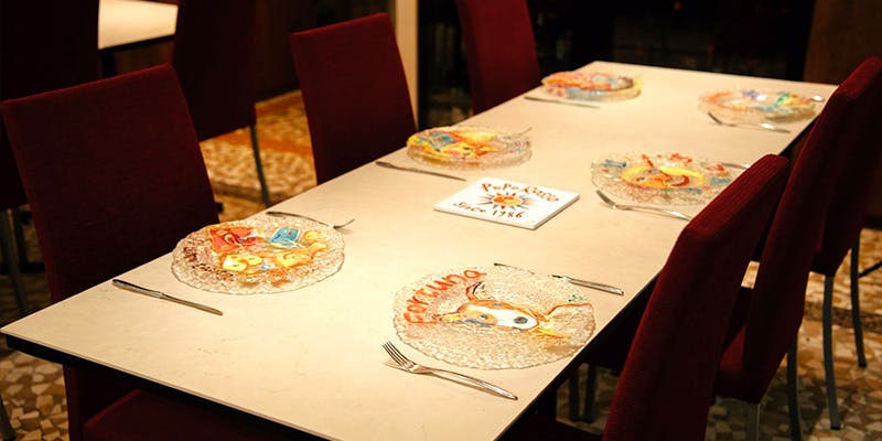 白いテーブルにセッティングされたガラスのお皿とカトラリー