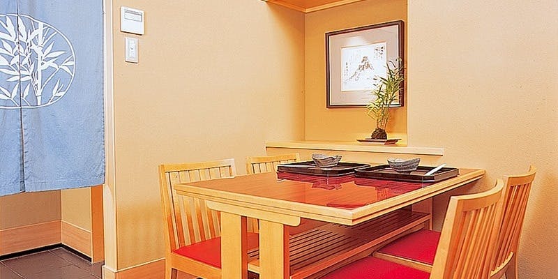 洗練された和の空間にテーブルとイスがある東京竹葉亭 名古屋店の内観