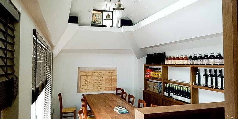 白を基調とした木のテーブルと椅子が並ぶアニマの内観