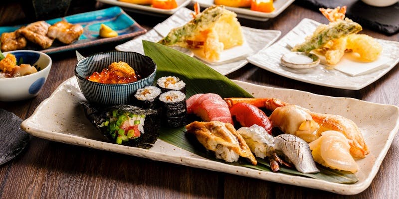 寿司や海苔巻き、天ぷらなどの和食が並んだテーブル