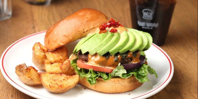 アボカドとチーズと野菜が挟まれたハンバーガー