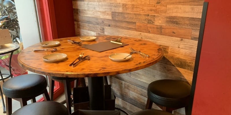 ウッドベースの落ち着いた店内に置かれた木の丸テーブル
