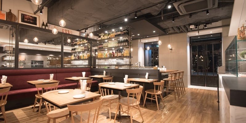 木のテーブルとイスや赤いソファがある内観