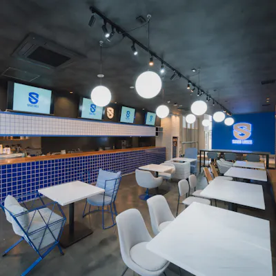 ブルーのカウンターが映える店内で、こだわりの食事を楽しむ
