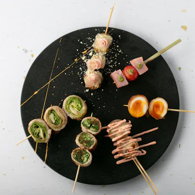 丁寧焼き上げる名物「野菜巻きと串焼きの盛り合わせ」。職人の技が光る極上の串