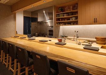 木の温もりに包まれたカウンターで、旬の鮨と日本酒のペアリングをお楽しみください